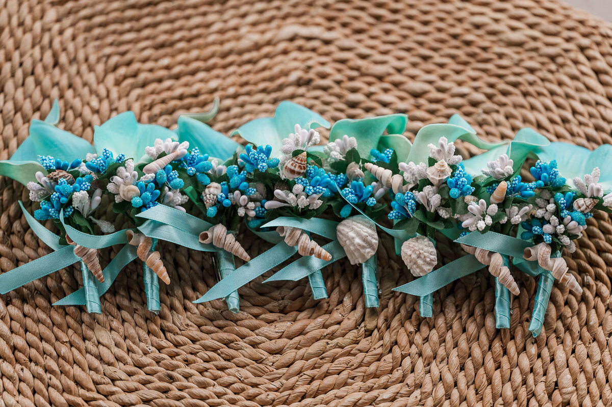 Teal seashell wedding boutonnieres on a wicker background by Raleigh wedding photographer, JoLynn Photography