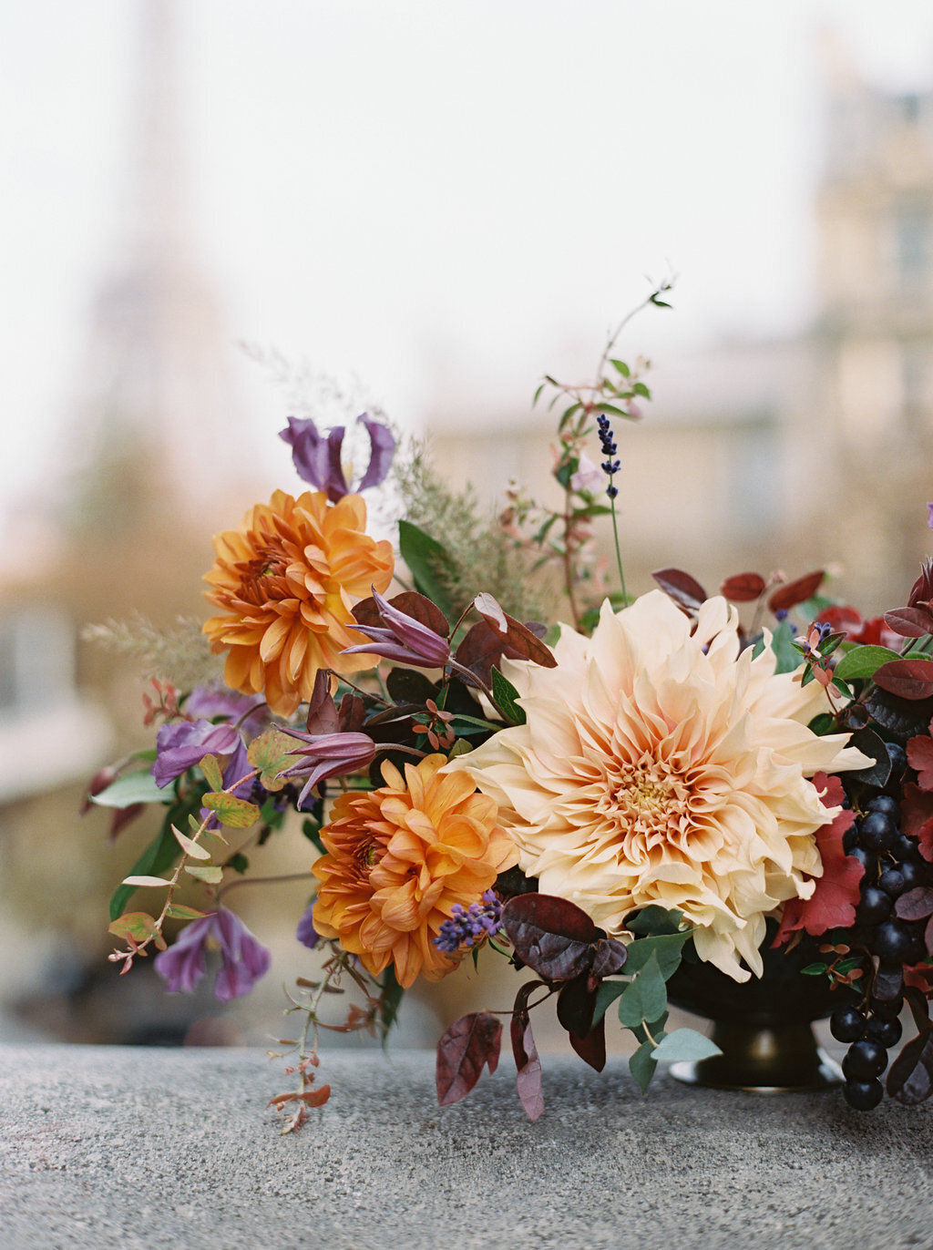 Parisian inspired floral design in autumn Paris wedding. Fall colored flowers of dahlias, berried, and branches. Design by Rosemary & Finch Floral Design in  Nashville, TN.