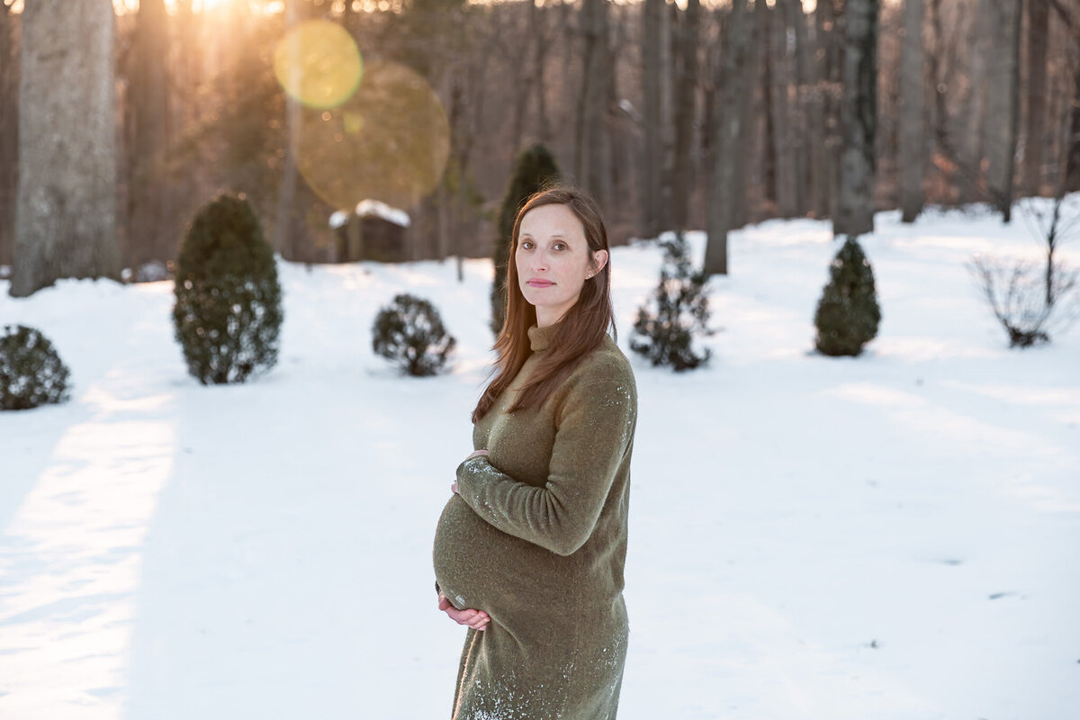 A Mother holds her baby bump during her Bel Air, MD maternity photos.