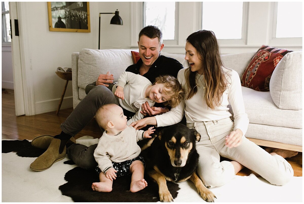 Family sitting on the floor at home with toddler, baby and dog