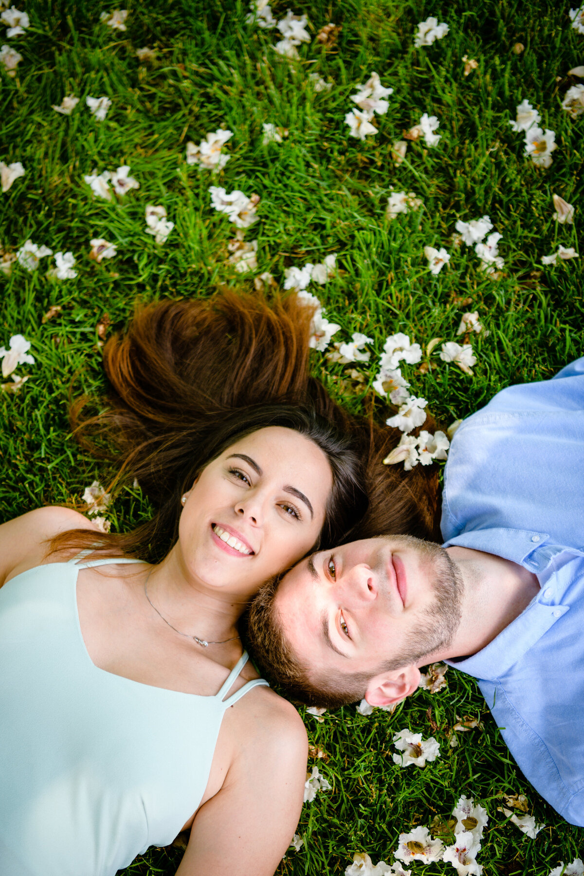 MA engaged couple laying in field of flowers