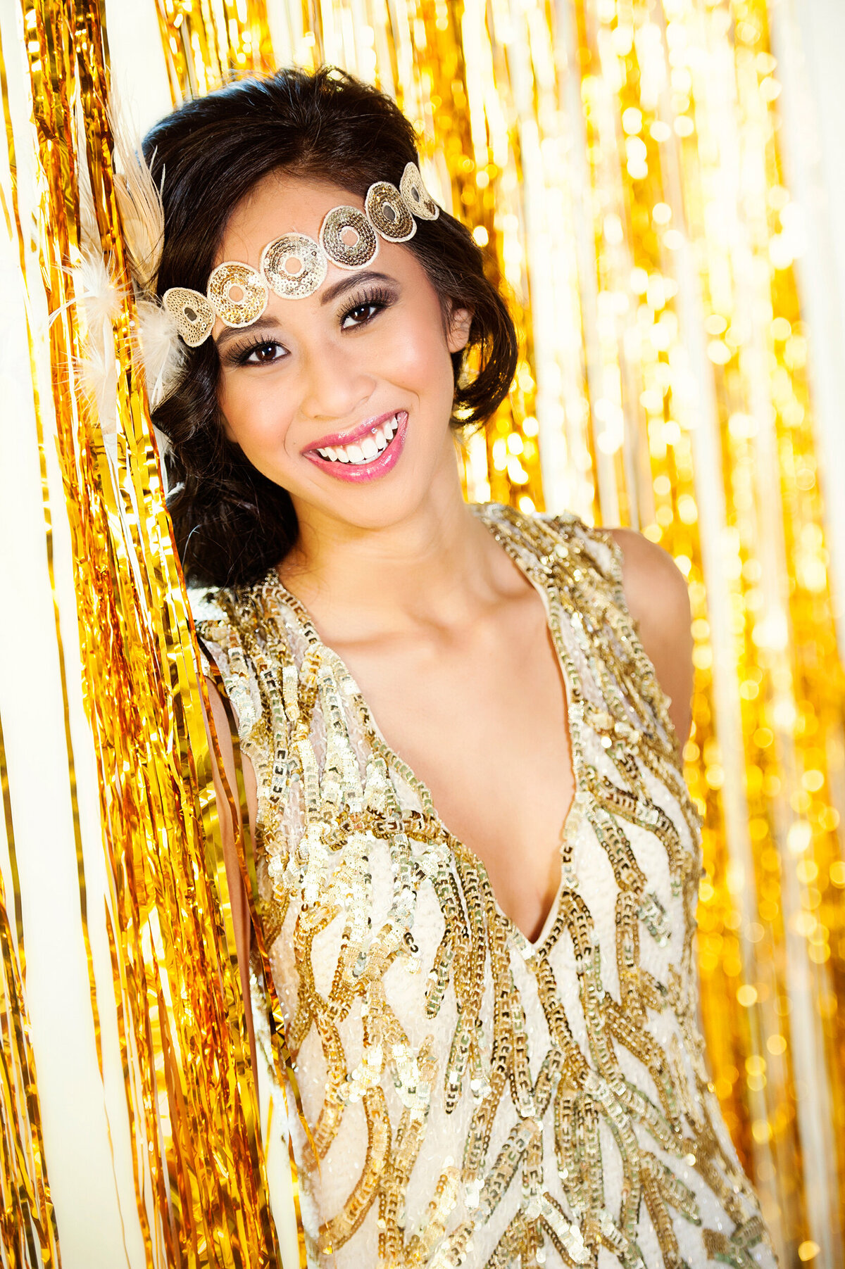 senior photo of girl in gold and white sequin dress and gold streamers