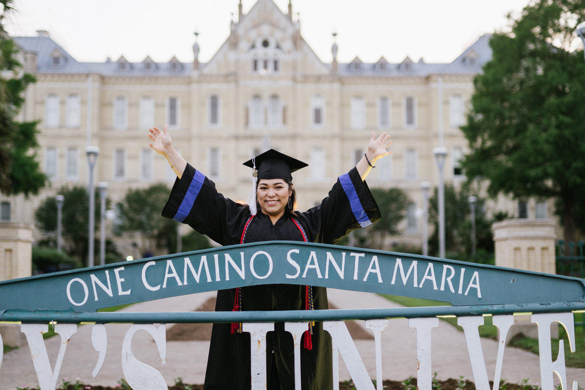 college senior posing at St. Mary's university sign by San Antonio college senior photographer