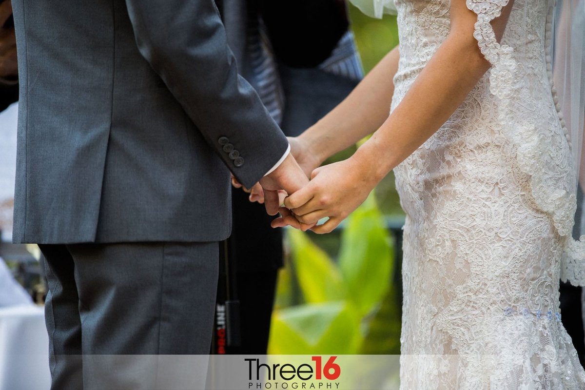Bride and Groom hold hands during their wedding