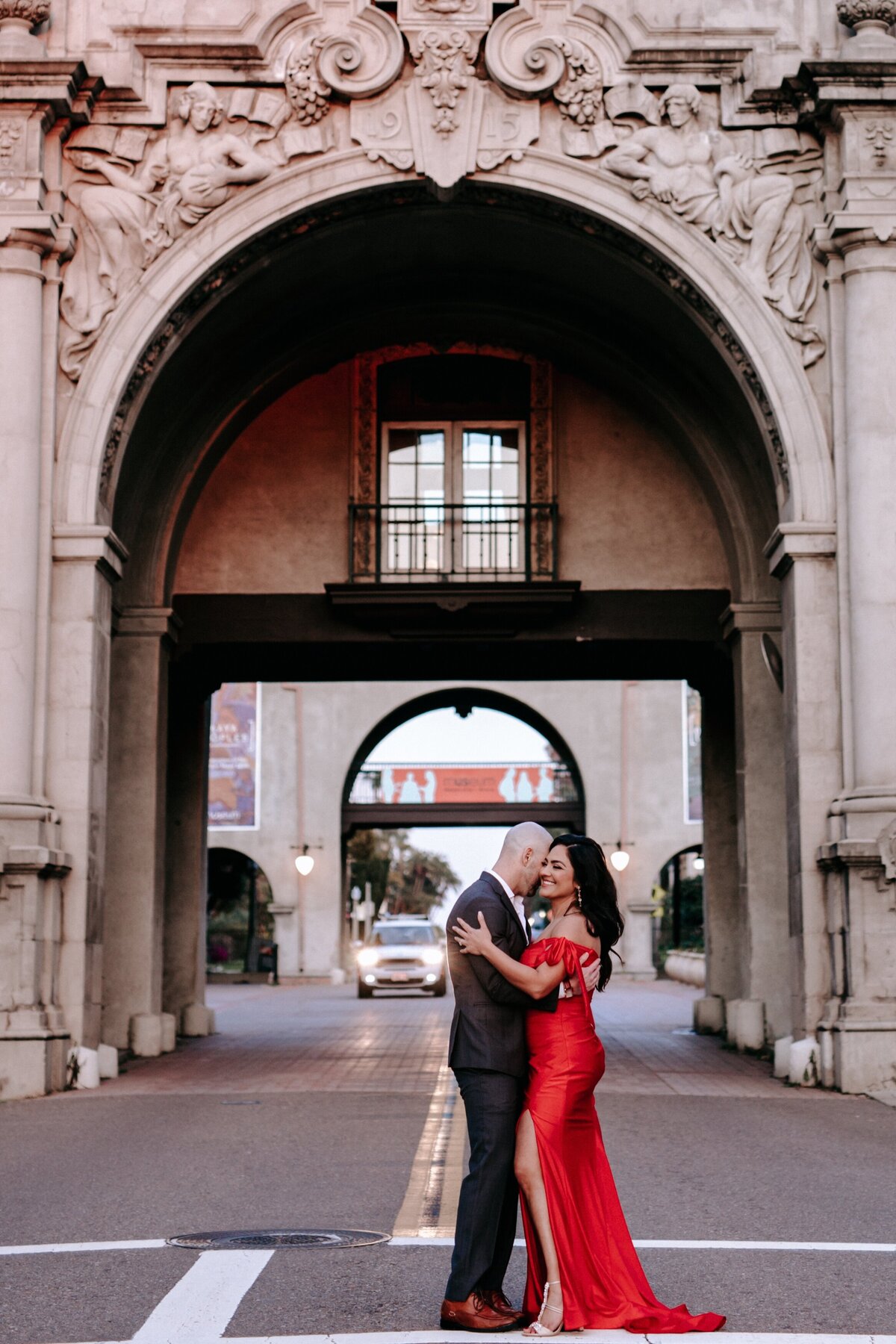 Photo of couple in the streets  in fancy attire and bride in a red dress.