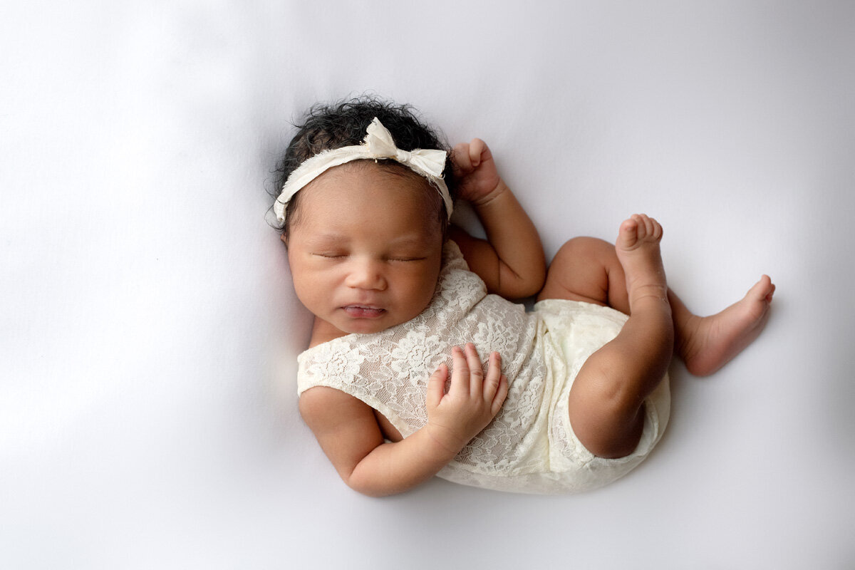 Newborn session of baby girl wearing a bow