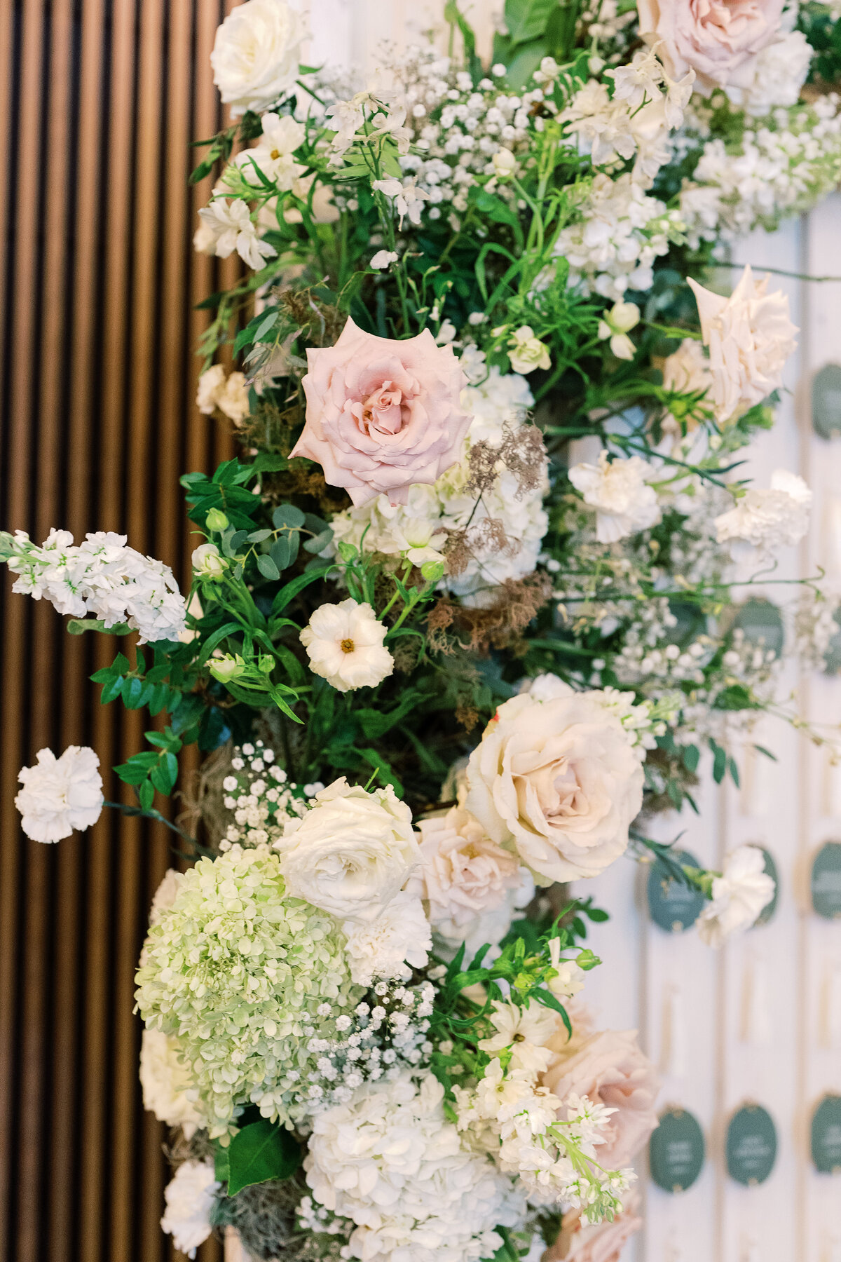 Floral Installation for escort display at timeless white and green wedding. Garden-inspired florals with roses, hydrangea, baby’s breath, and ranunculus. Summer wedding in downtown Nashville. Design by Rosemary & Finch in Nashville, TN.