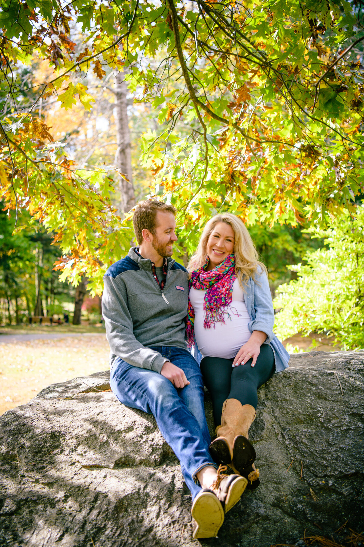 Benson Park maternity session with couple sitting on rock