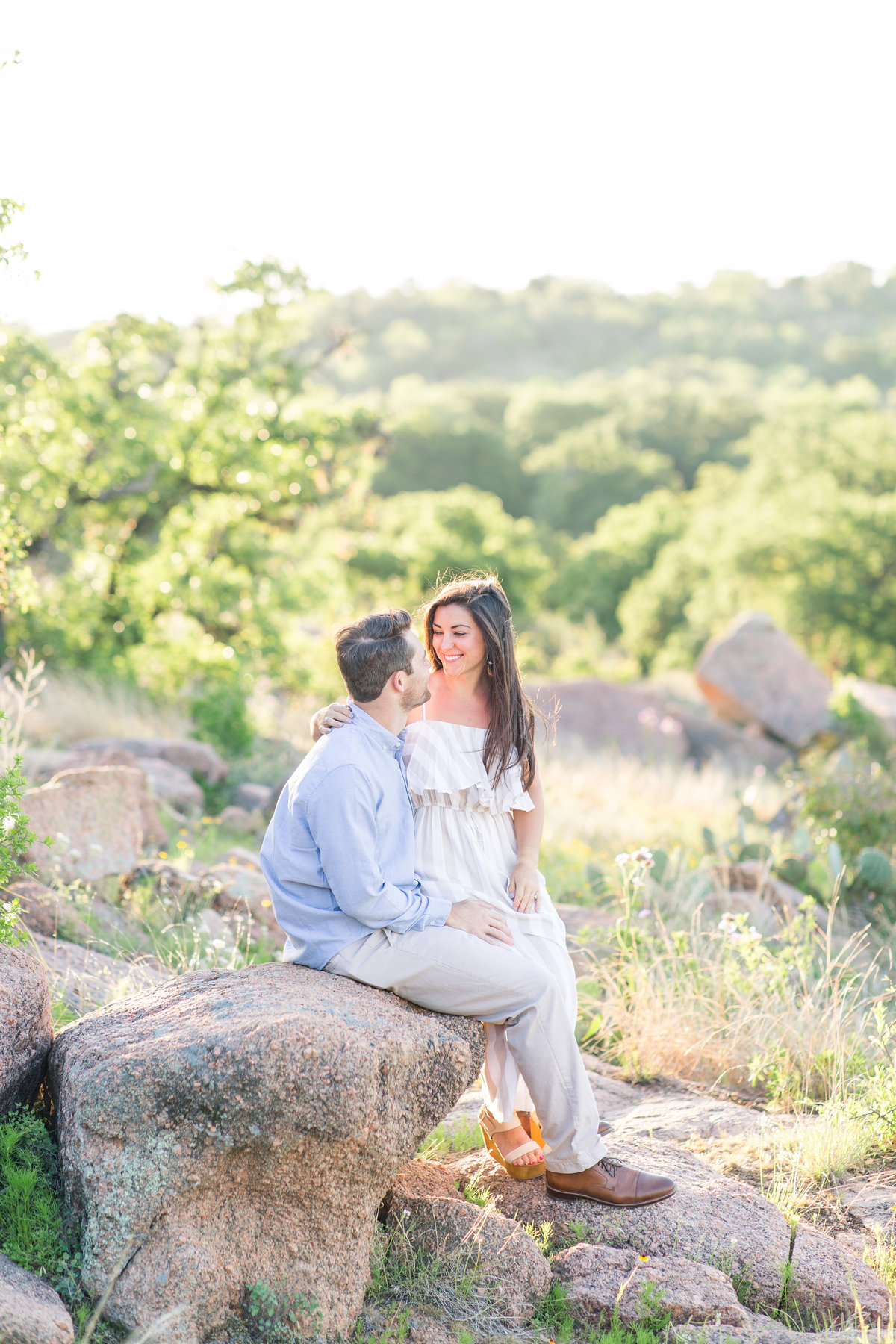 Engagement photos of couple embracing at Enchanted Rock; Fredricksburg, Texas