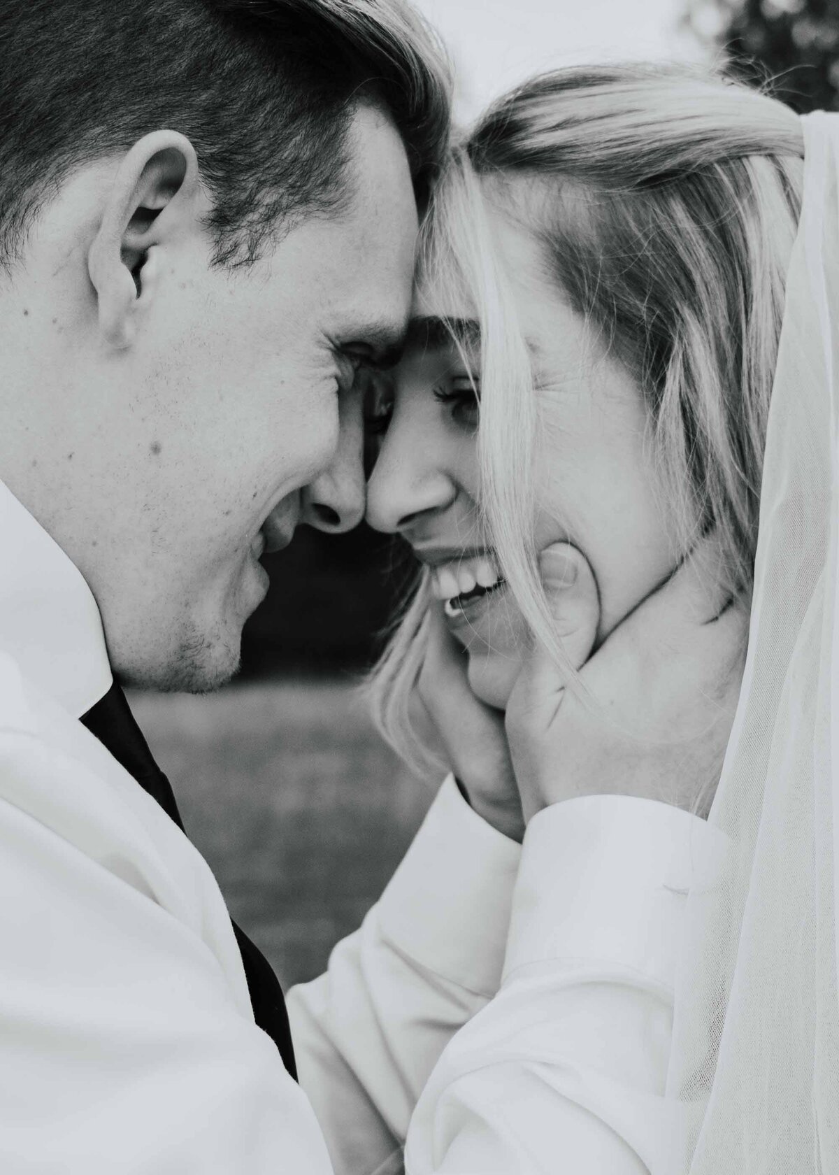 Maddie Rae Photography black and white close u p of bride and groom touching foregeads. his hands are on her face and they are smiling at each other