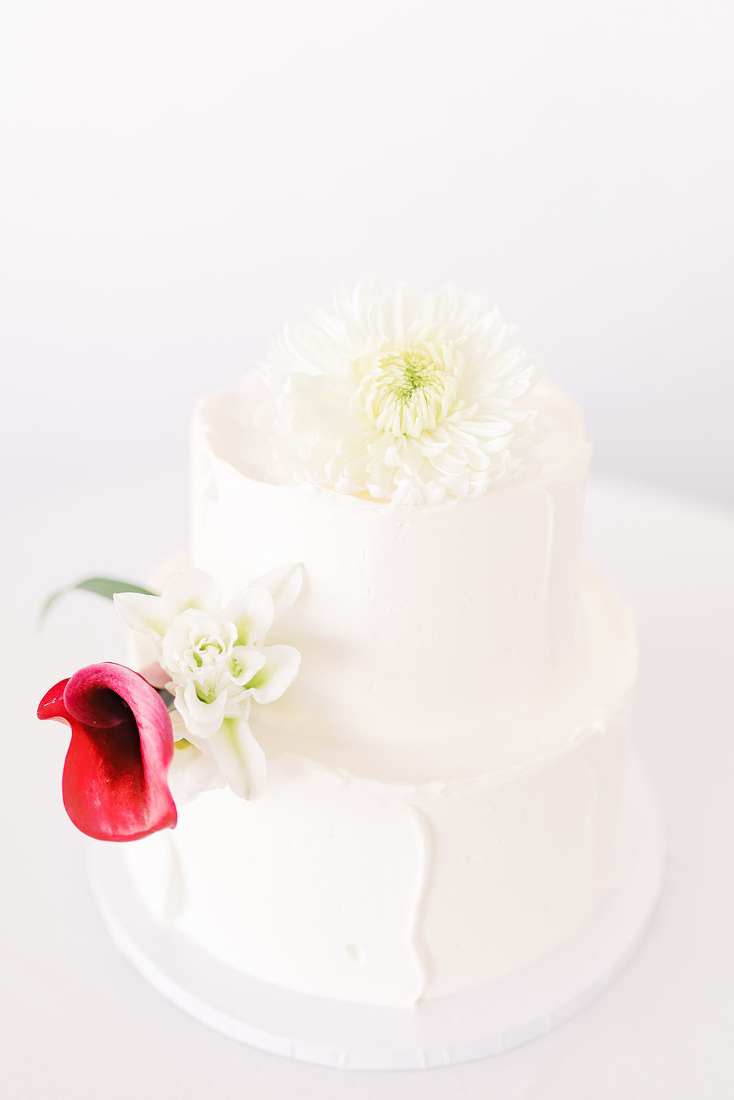 White wedding cake with red flower