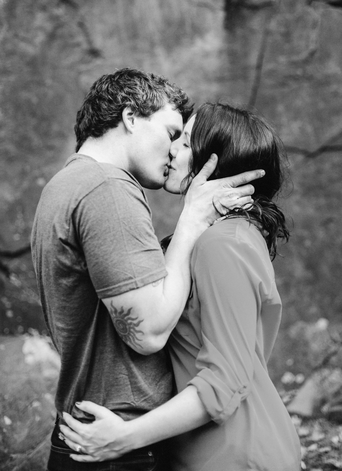 engagement session kissing black and white in front of stone of taylors falls state park