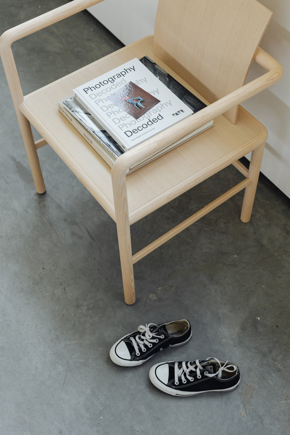 kaboompics_wooden-minimalist-chair-magazines-and-books-converse-sneakers-22088