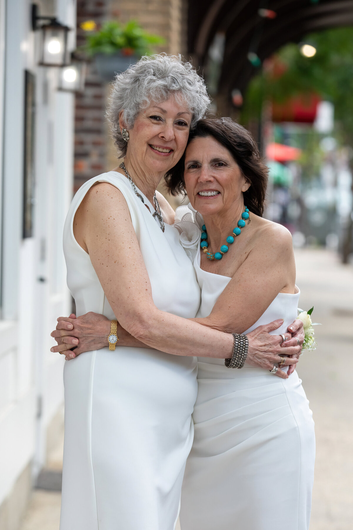 Two middle-aged women in white dresses hug at their wedding LGBTQ lesbian Nyack New York wedding photographer Milestone Images