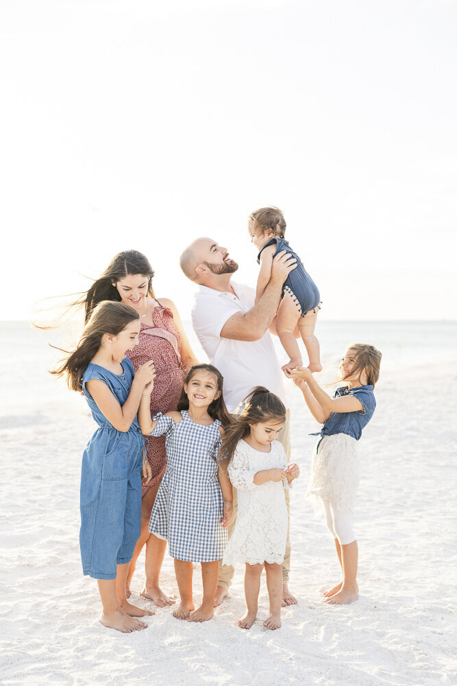 a family posing on the beach