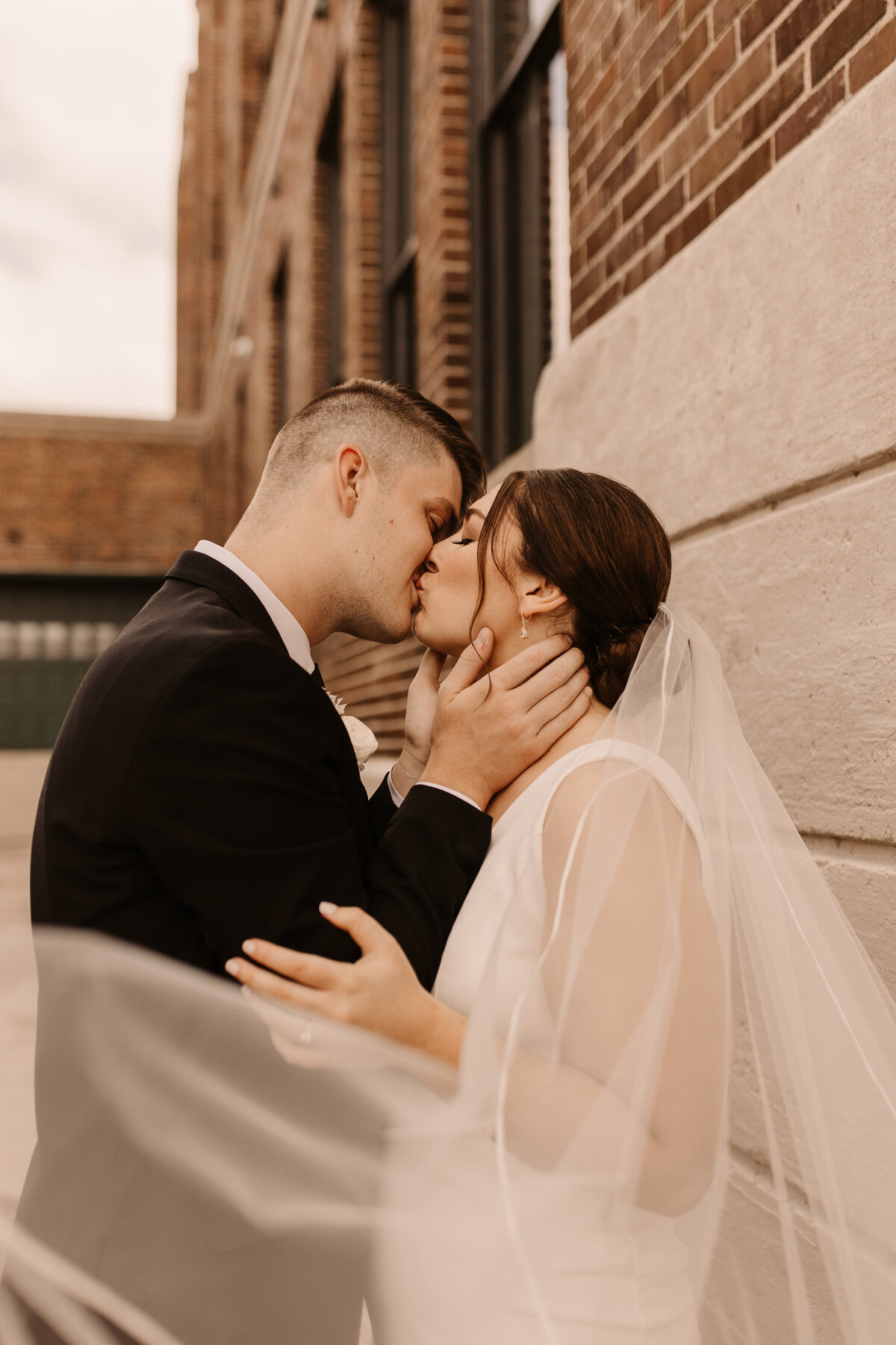 bride and groom kissing with long veil