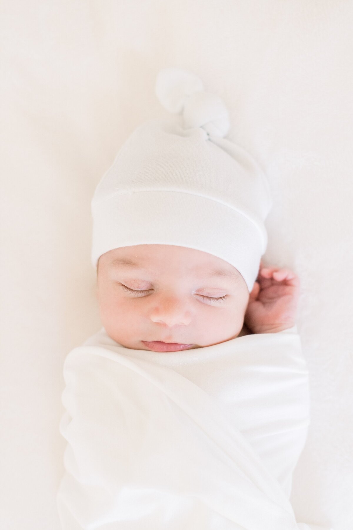 sleeping newborn swaddled in white by westchester newborn photographer
