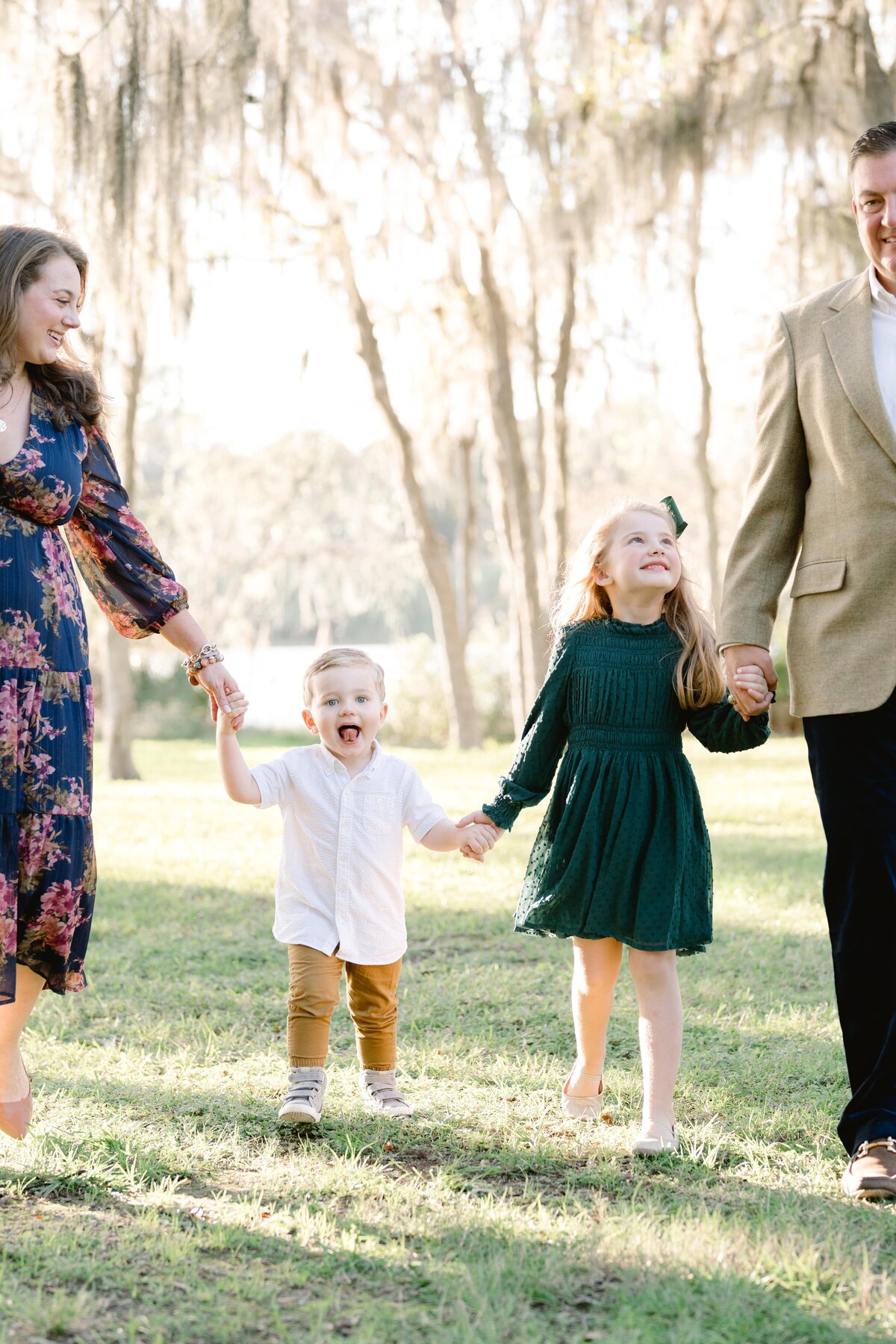 Family portrait holding hands walking in field