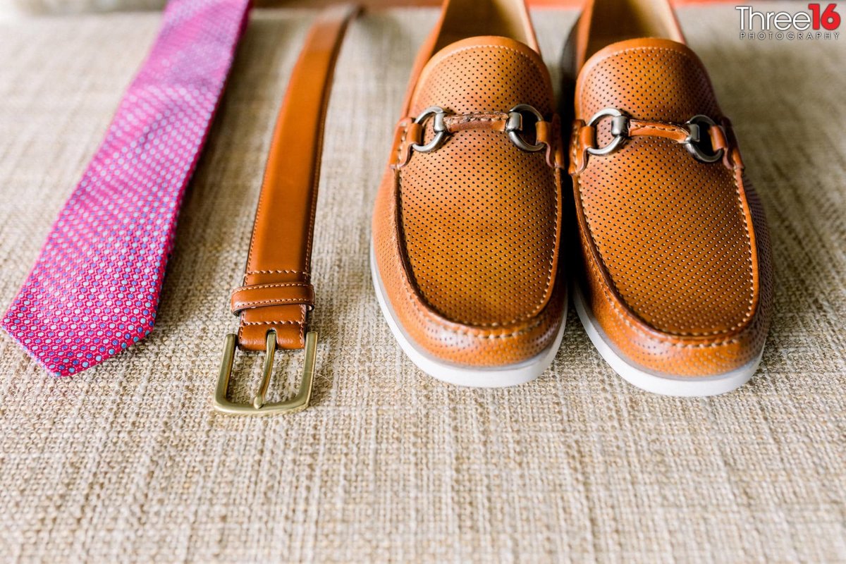 Groom's brownish shoes, brownish belt and  pinkish tie