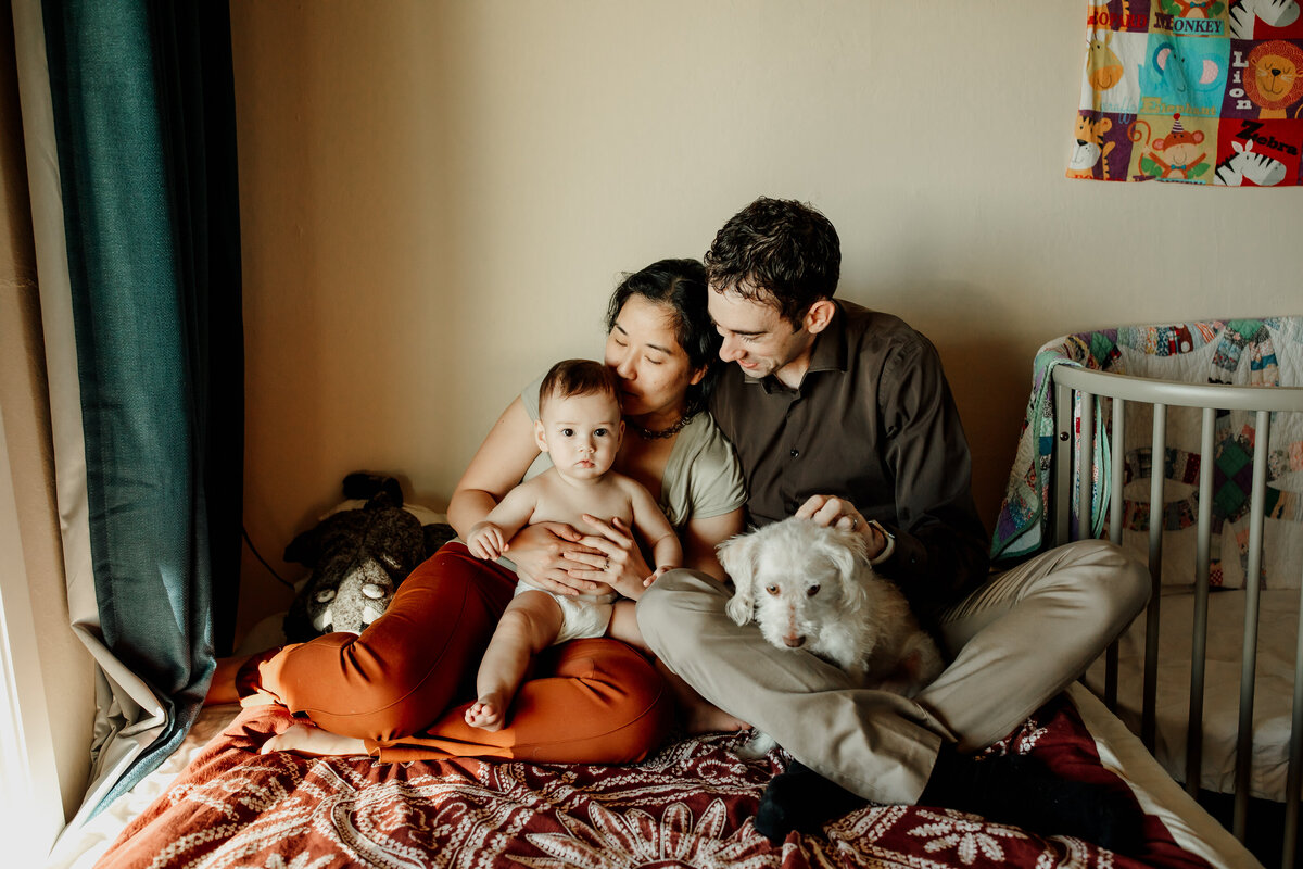 San Francisco family snuggles with baby and dog in home lifestyle photography session