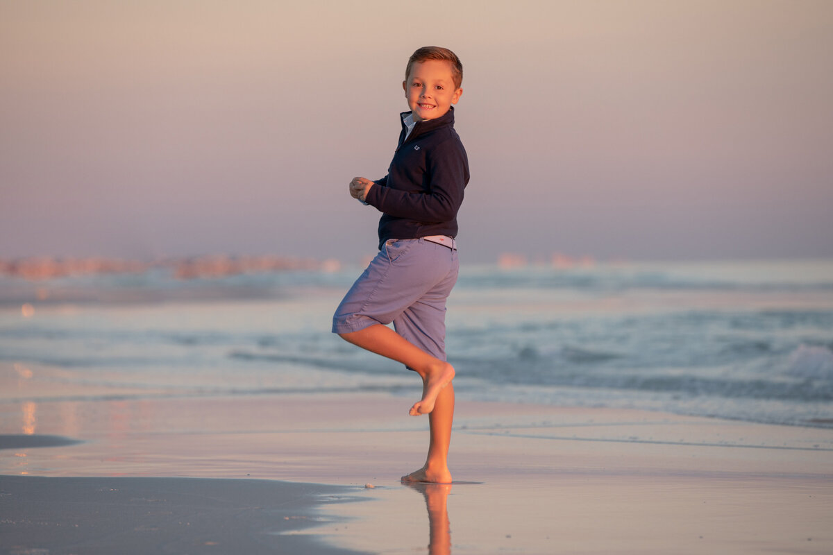 A small boy standing at the water's edge