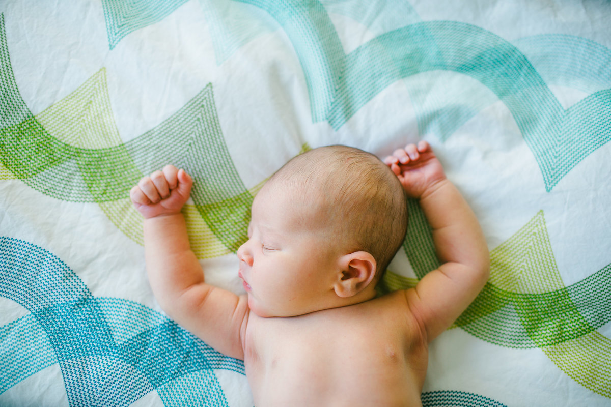 Newborn girl with arms above head