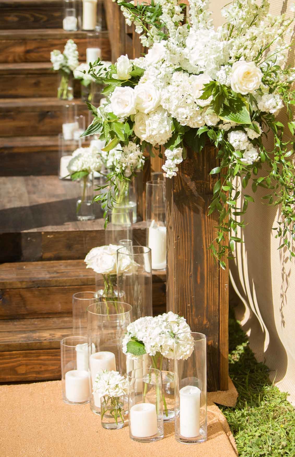 Large white flower arrangement and candles on a wooden staircase
