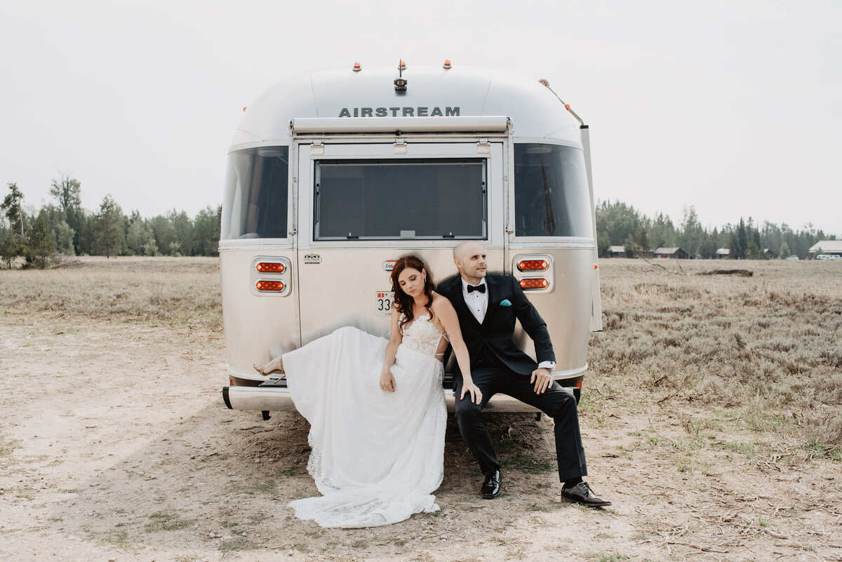 Jackson Hole photographers capture bride and groom sitting on airstream
