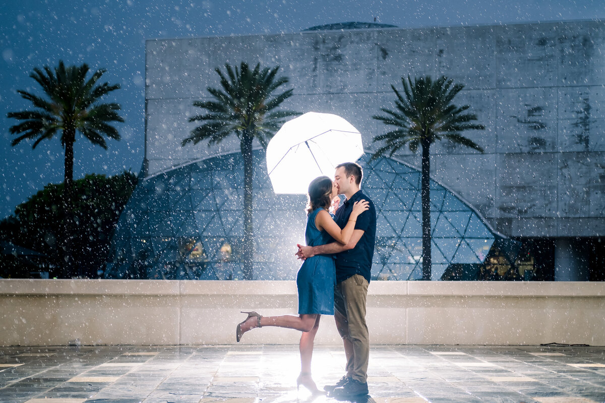 Engagement session in the rain outside of the Dali Museum with the umbrella lit up