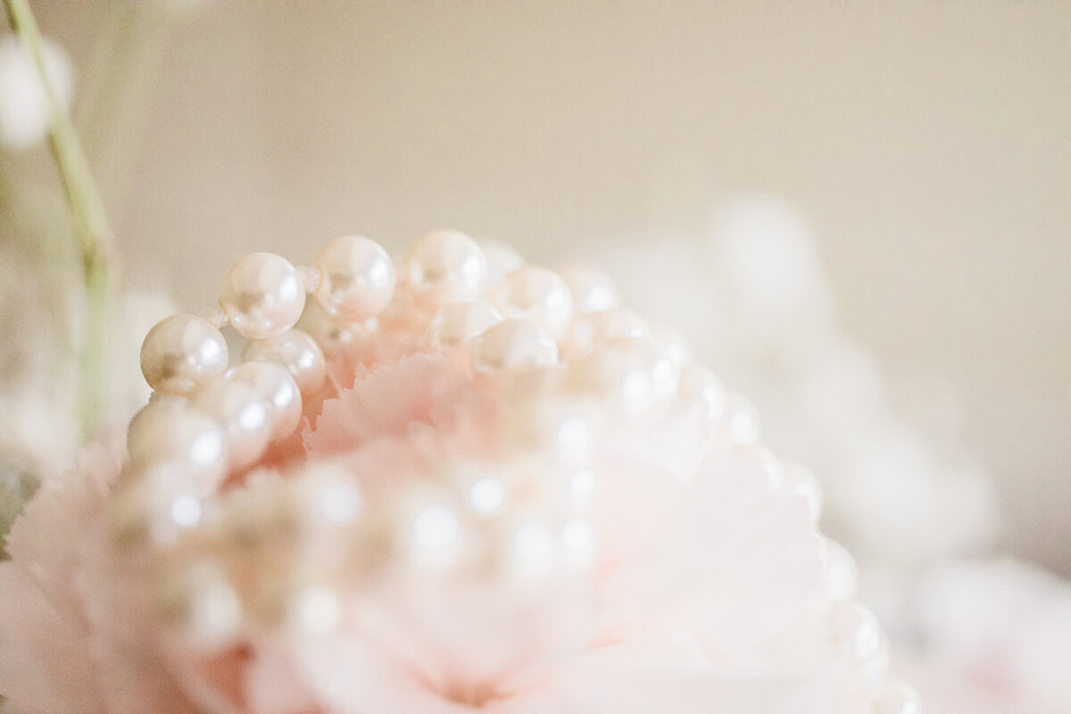 Pearl necklace on top of pink flower