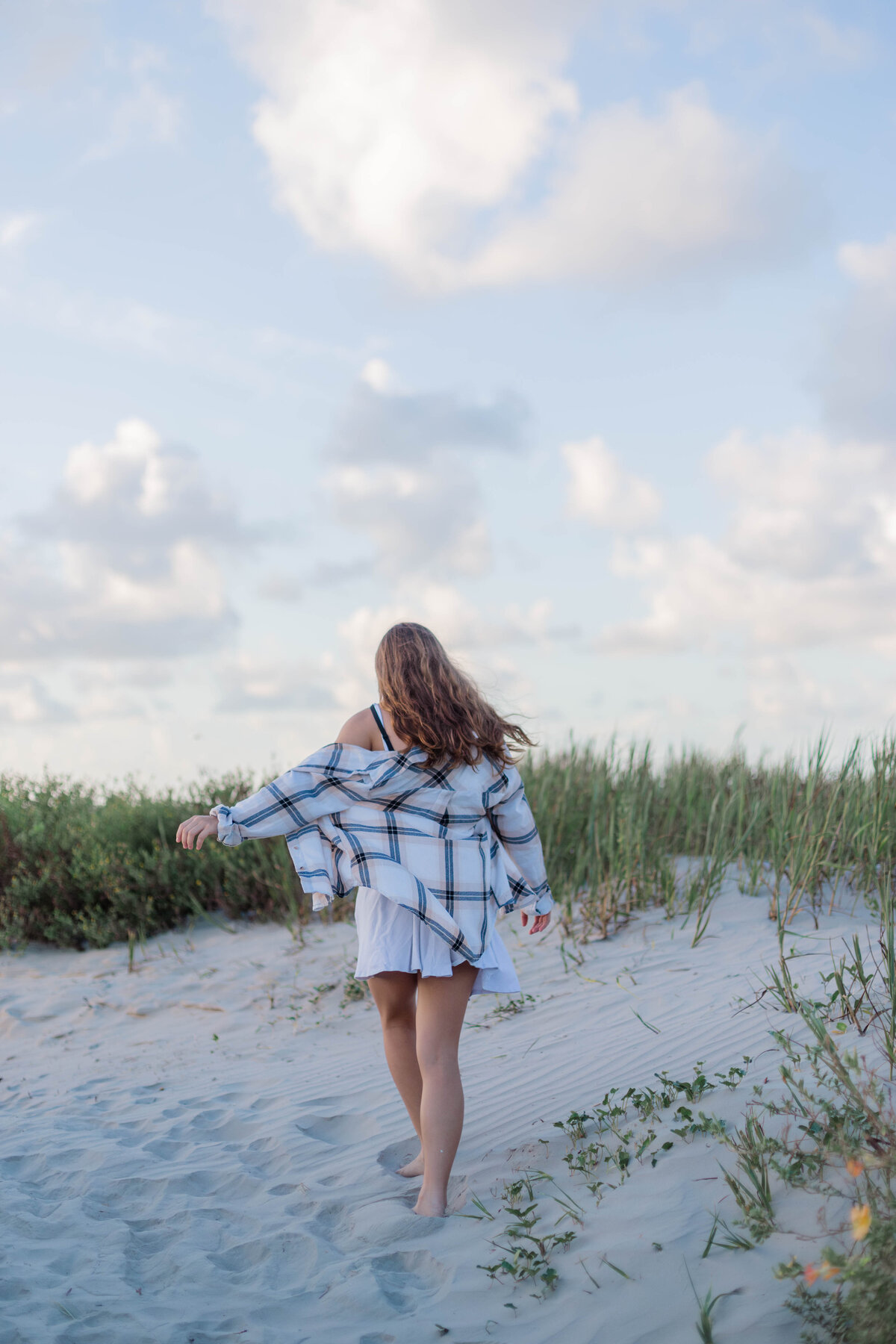 Senior young woman walks through the sand in Galveston
