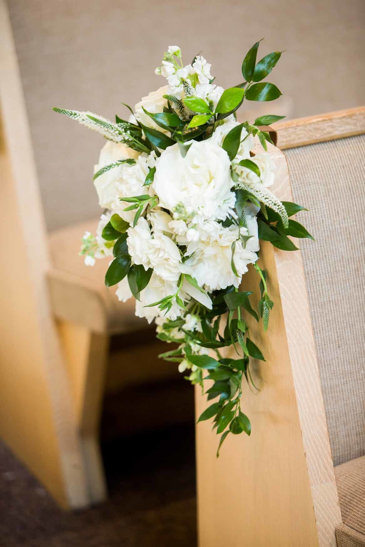 Wedding ceremony pew clips with roses and greenery
