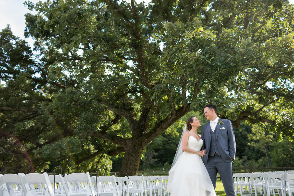 Mayowood Stone Barn as the perfect backdrop for a photograph of the bride and groom just in front of their empty ceremony location with chairs