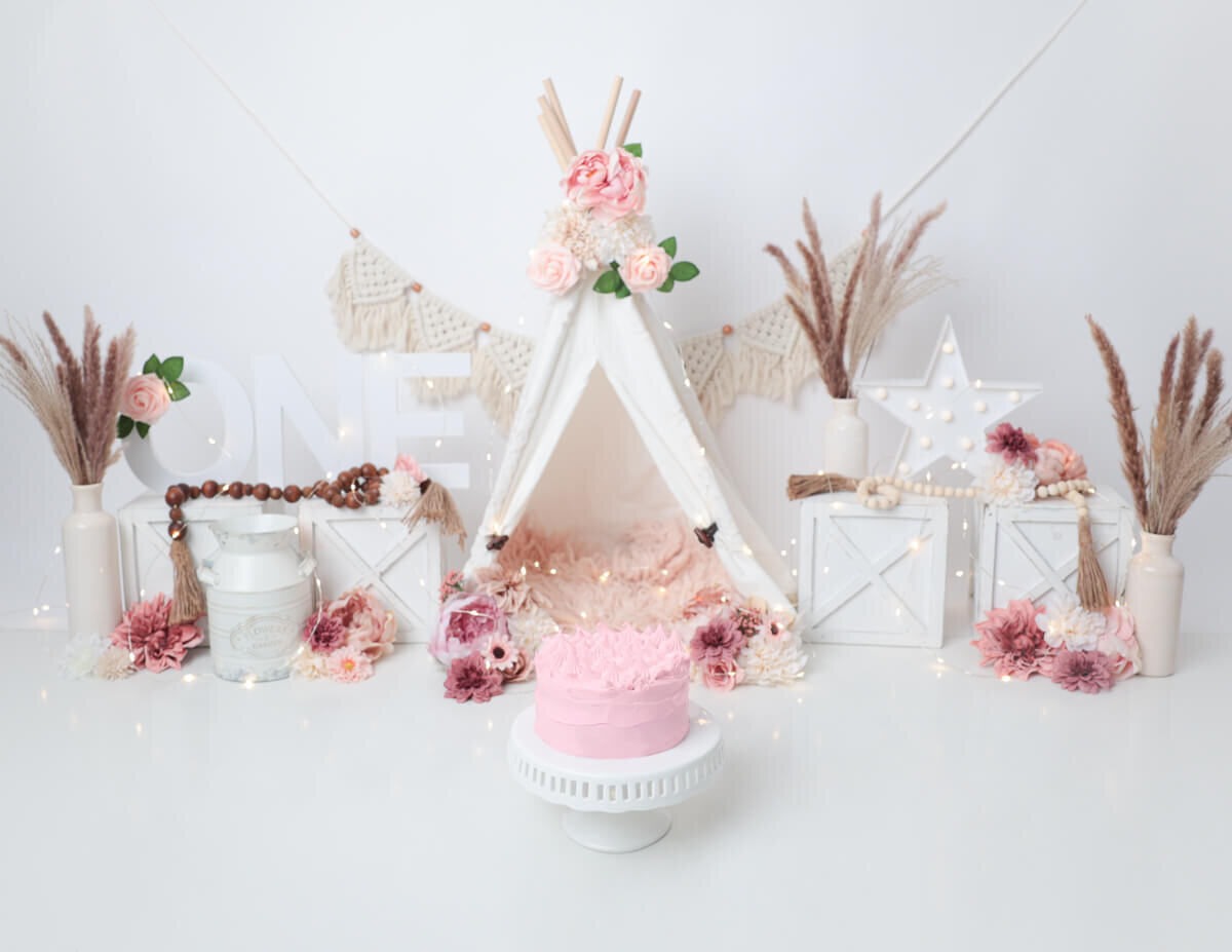 Beautifully styled boho cake smash scene with a decorated cake and playful props in Rochester, NY.