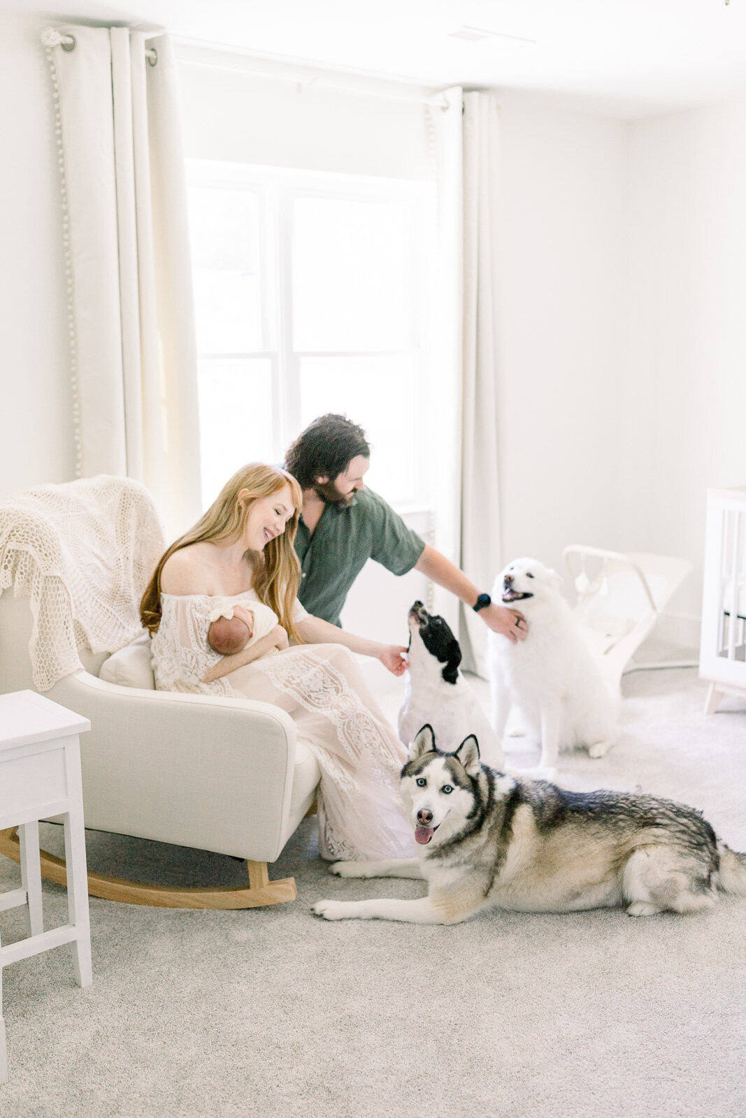 New parents snuggling baby and dogs