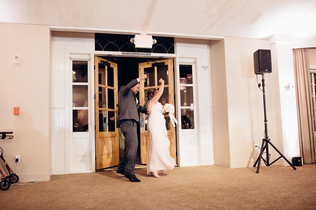 Wedding Photograph Of Groomsman And Bridesmaid Raising Their Hands While Entering  The Door Of The Reception Hall Los Angeles