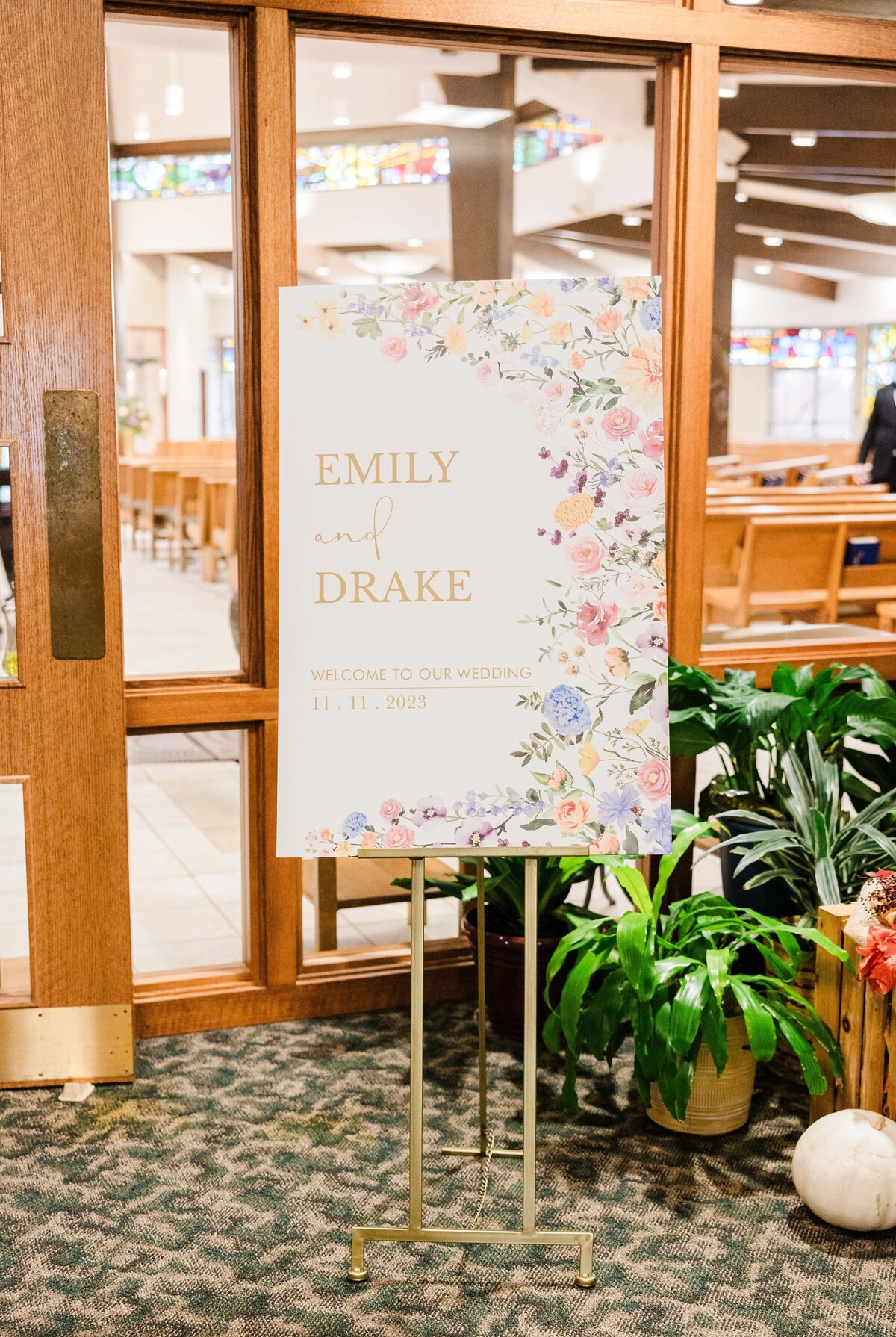 A wedding welcome sign featuring the names “Emily and Drake” with a floral border, dated November 1, 2023, standing in the entrance of Park Farm Winery.