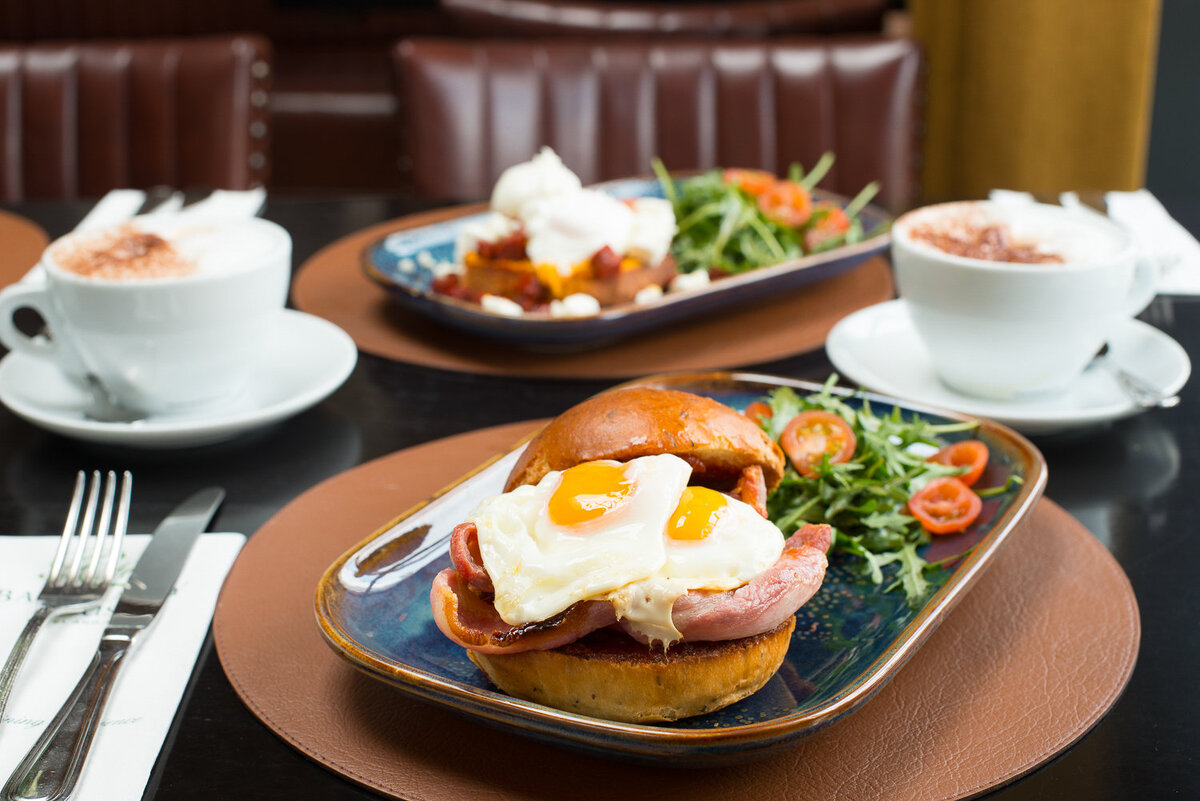 eggs and bacon in a bap with coffee
