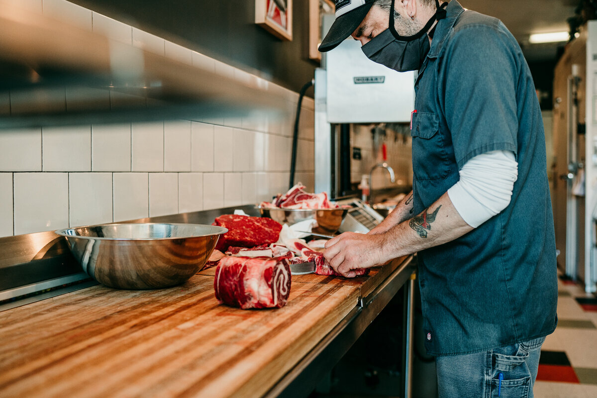 butcher preps meat in kitchen