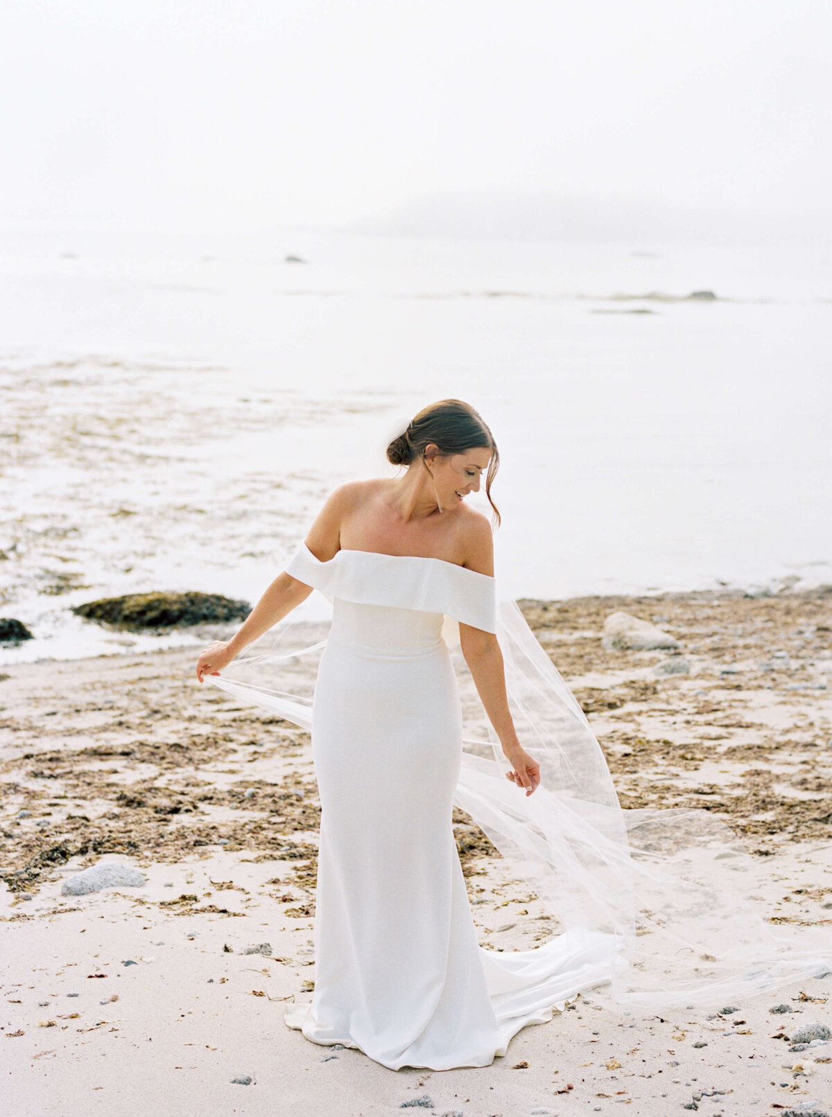 Bride with veil flowing on sand at Oceanstone Resort Wedding in Nova Scotia