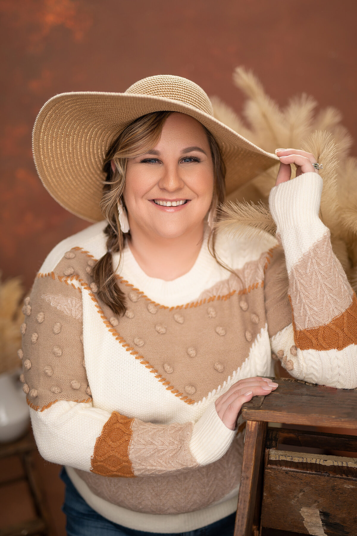 A professional headshot of a woman wearing a color block sweater and floppy hat taken in our Waukesha, WI photo studio.
