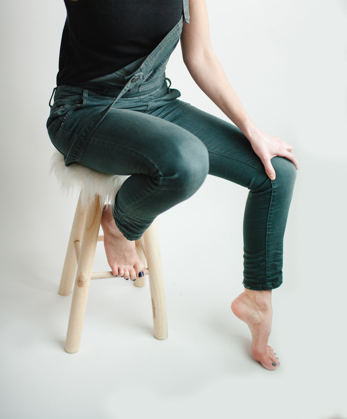artist portrait of legs on a stool over a white background