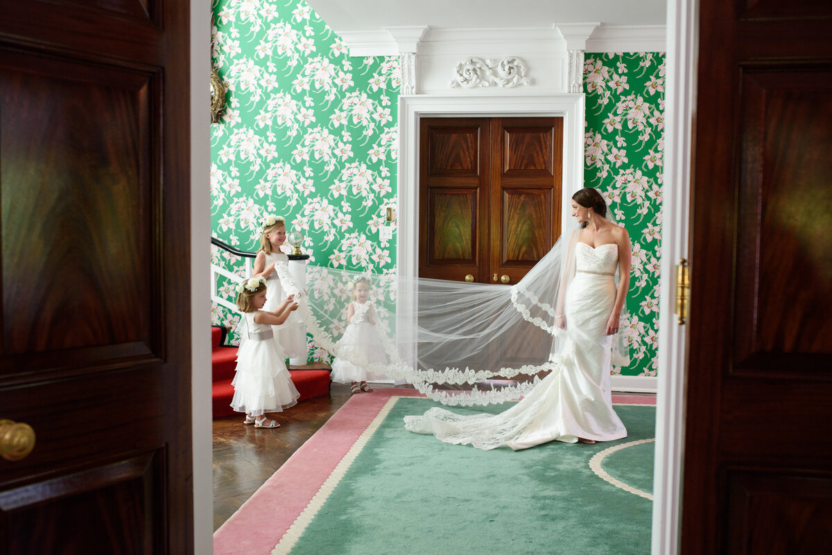 image of three flower girls helping bride with her veil