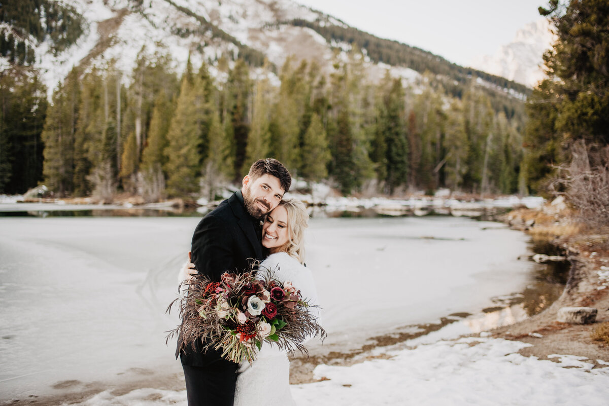 Jackson Hole Photographers capture couple hugging in front of Tetons after winter elopement