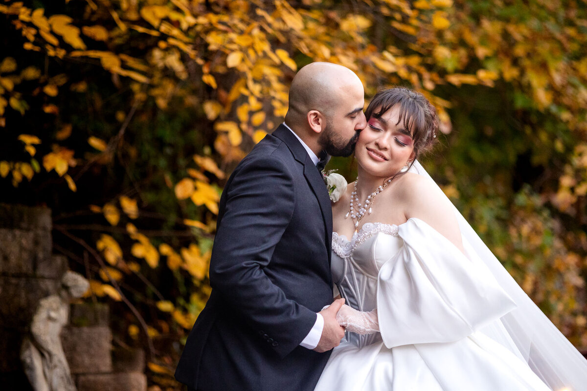groom kissing a bride at their wedding at Rocky's Lake Estate 