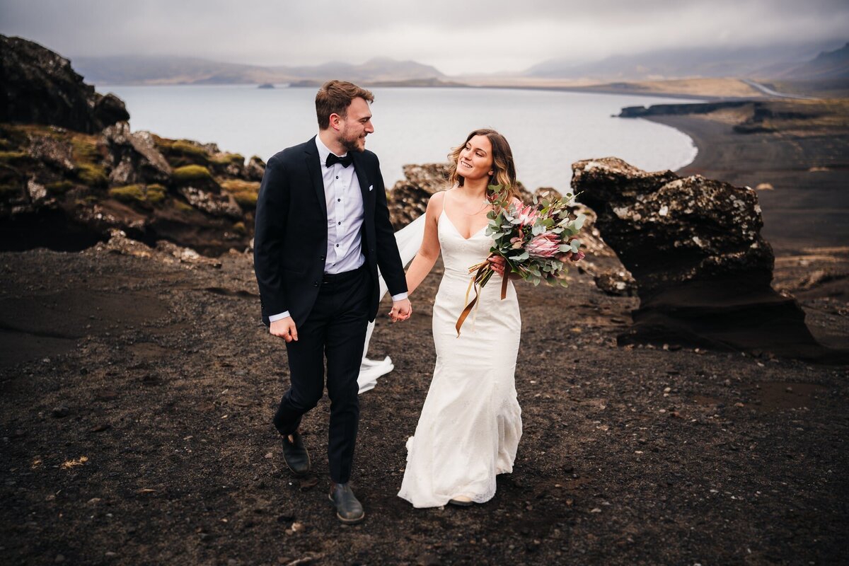 Hand in hand, strolling along the Icelandic coast, this couple shares a gaze filled with love and connection.
