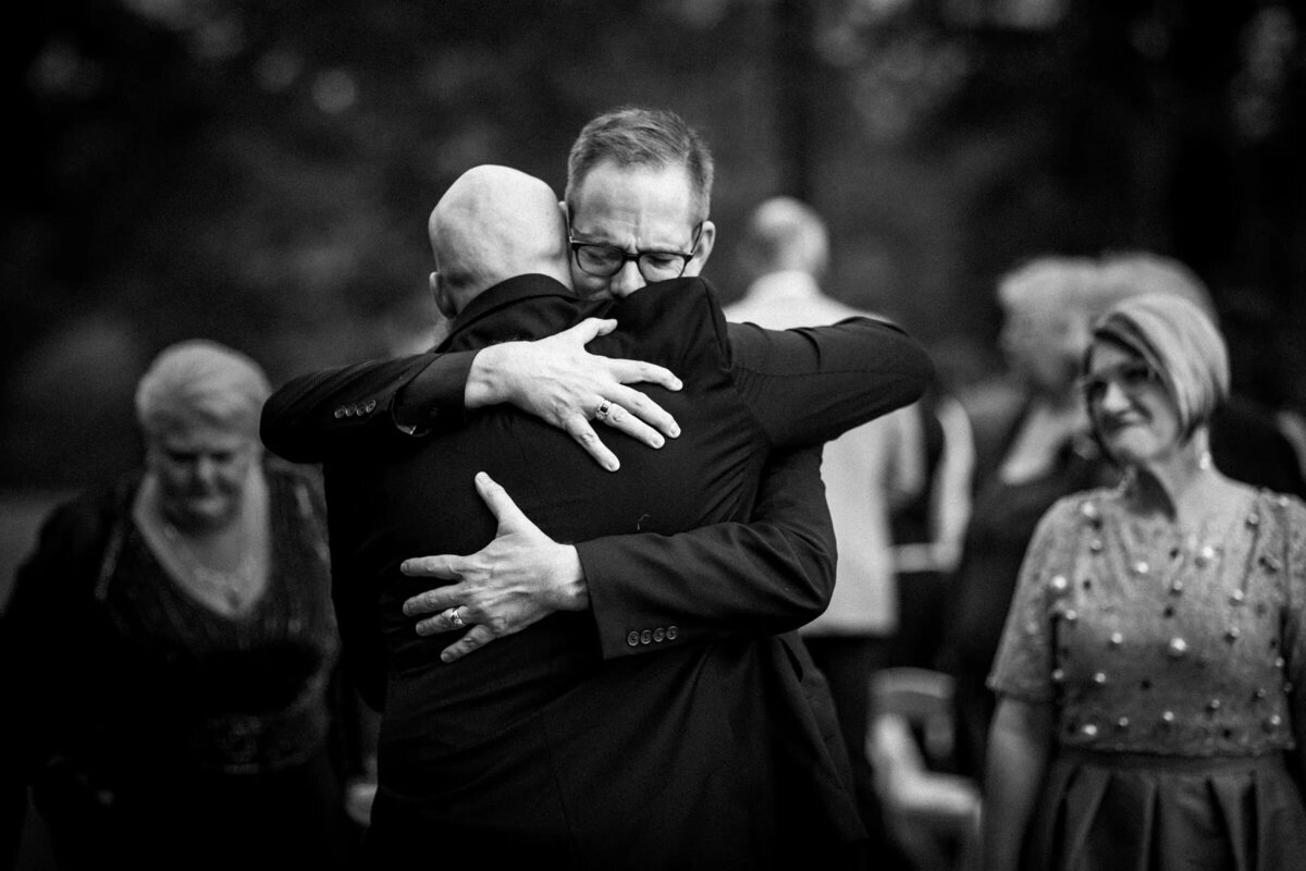 A heartfelt embrace between two men at a wedding
