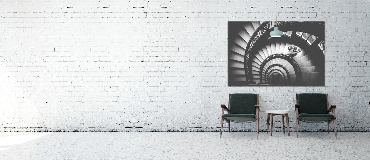 A large art canvas  mounted on a white brick wall.