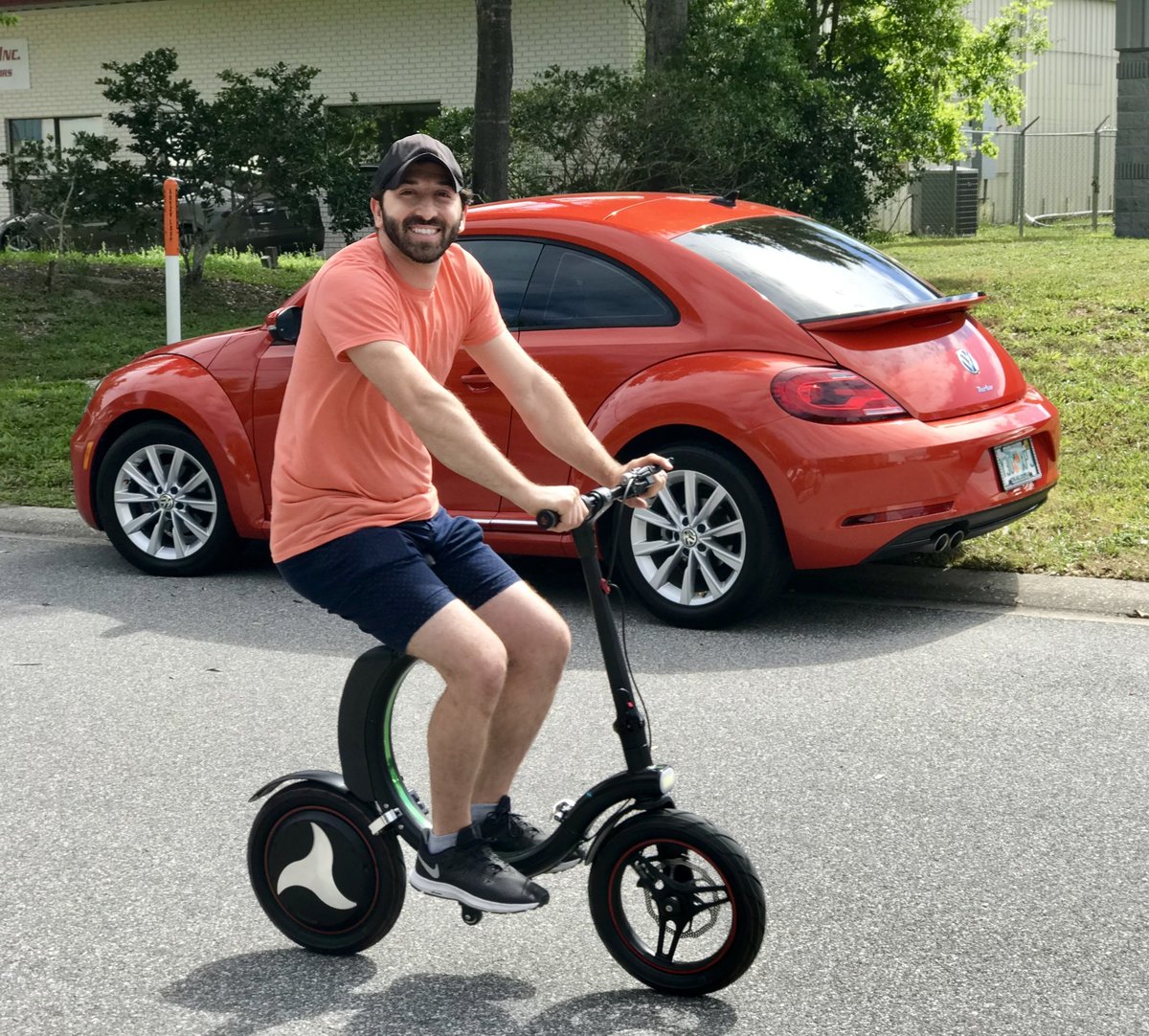 Guy riding his Go-Bike Q1 after parking his Red Volkswagon