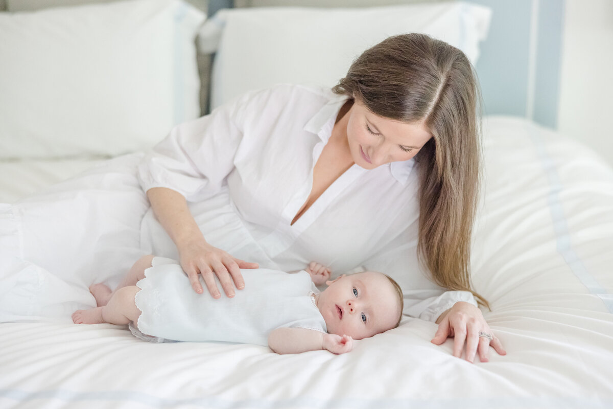 Mother holding her newborn while the father looks down at the baby.